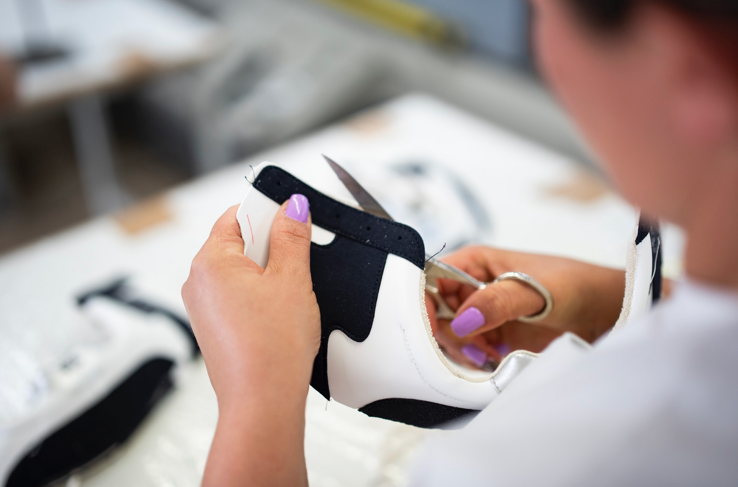 Un artisan portugais travaillant sur une paire de baskets Mood Walk dans un atelier lumineux.